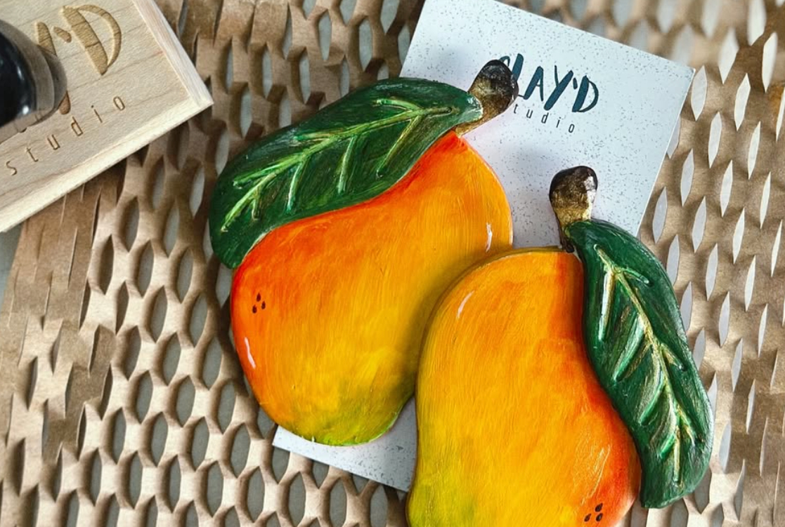 two decorative fruit magnets on a table