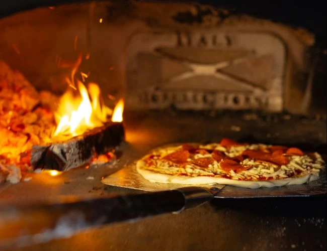 a pizza being baked in a stone oven
