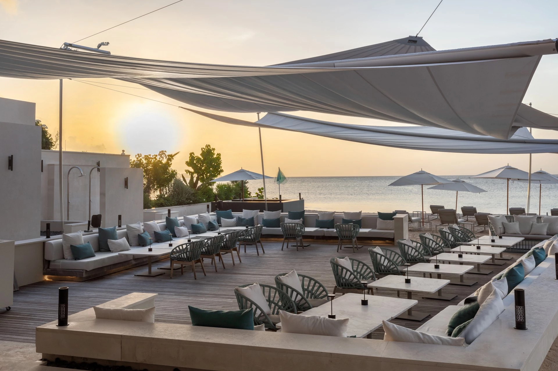 a large outdoor patio area with white chairs and umbrellas