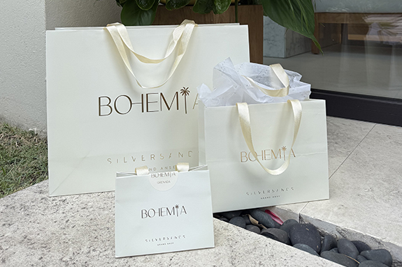 a group of white bags with gold text