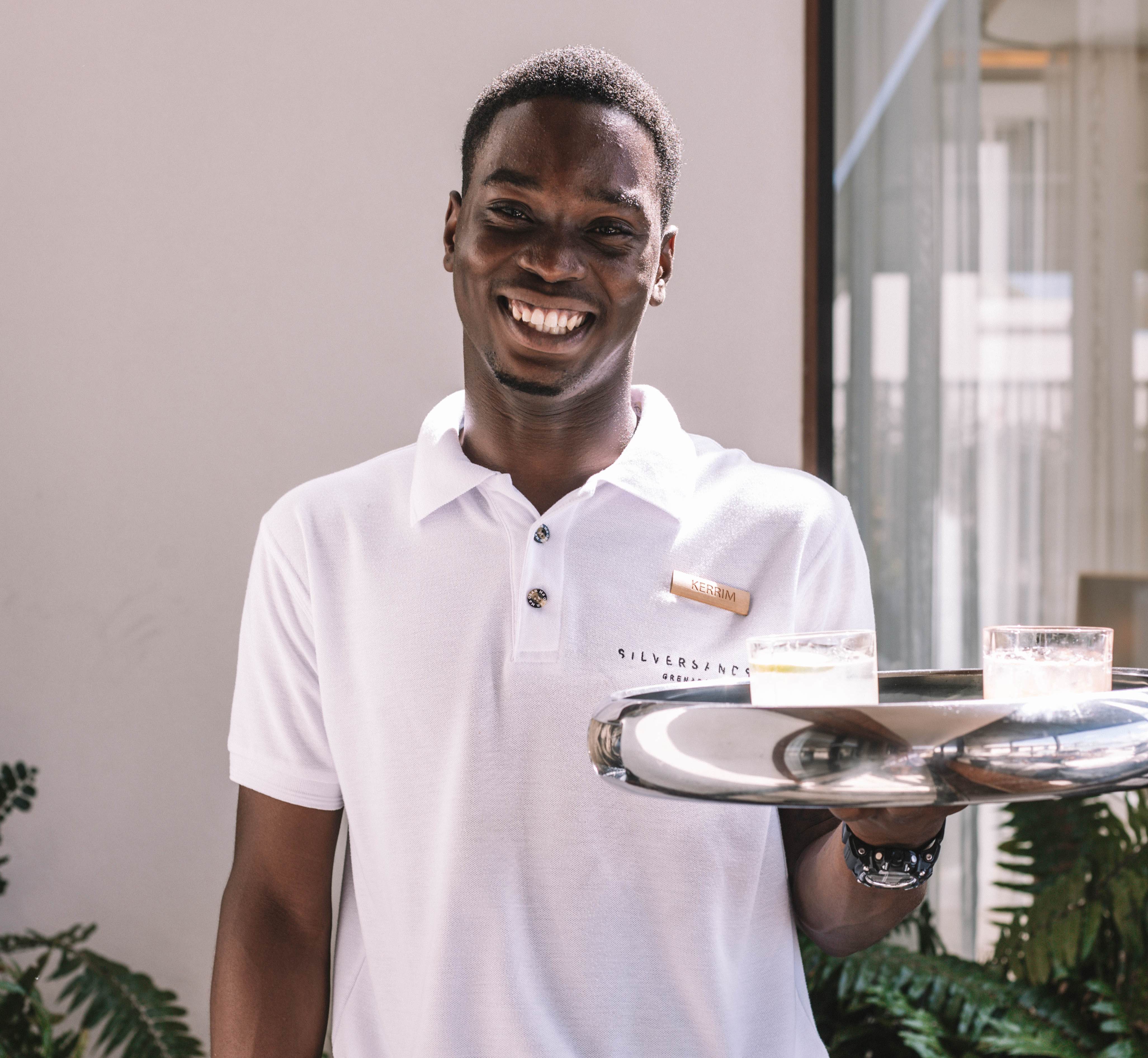 a man holding a tray of drinks