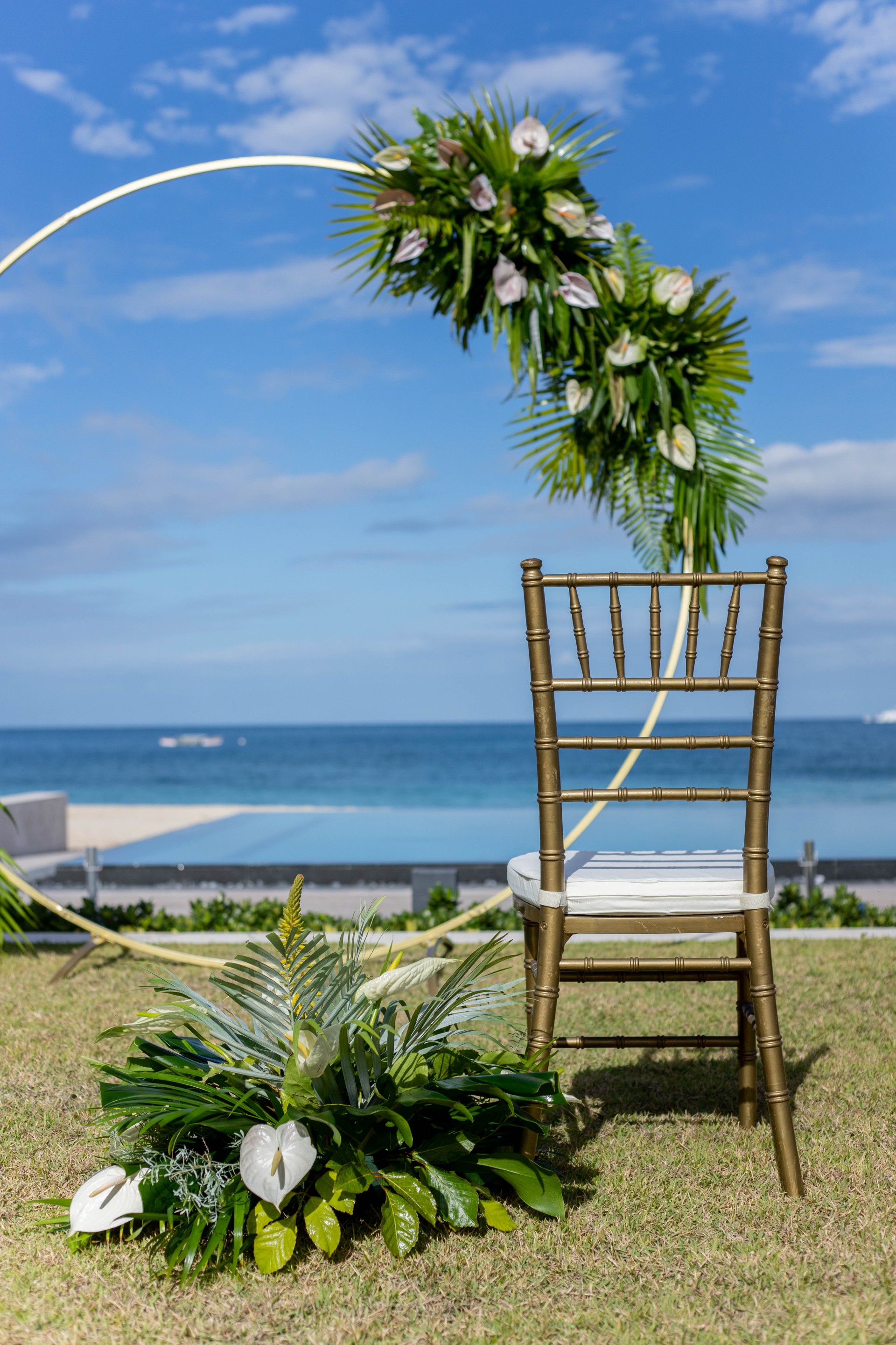 a chair in a grass area with a beach and water in the background
