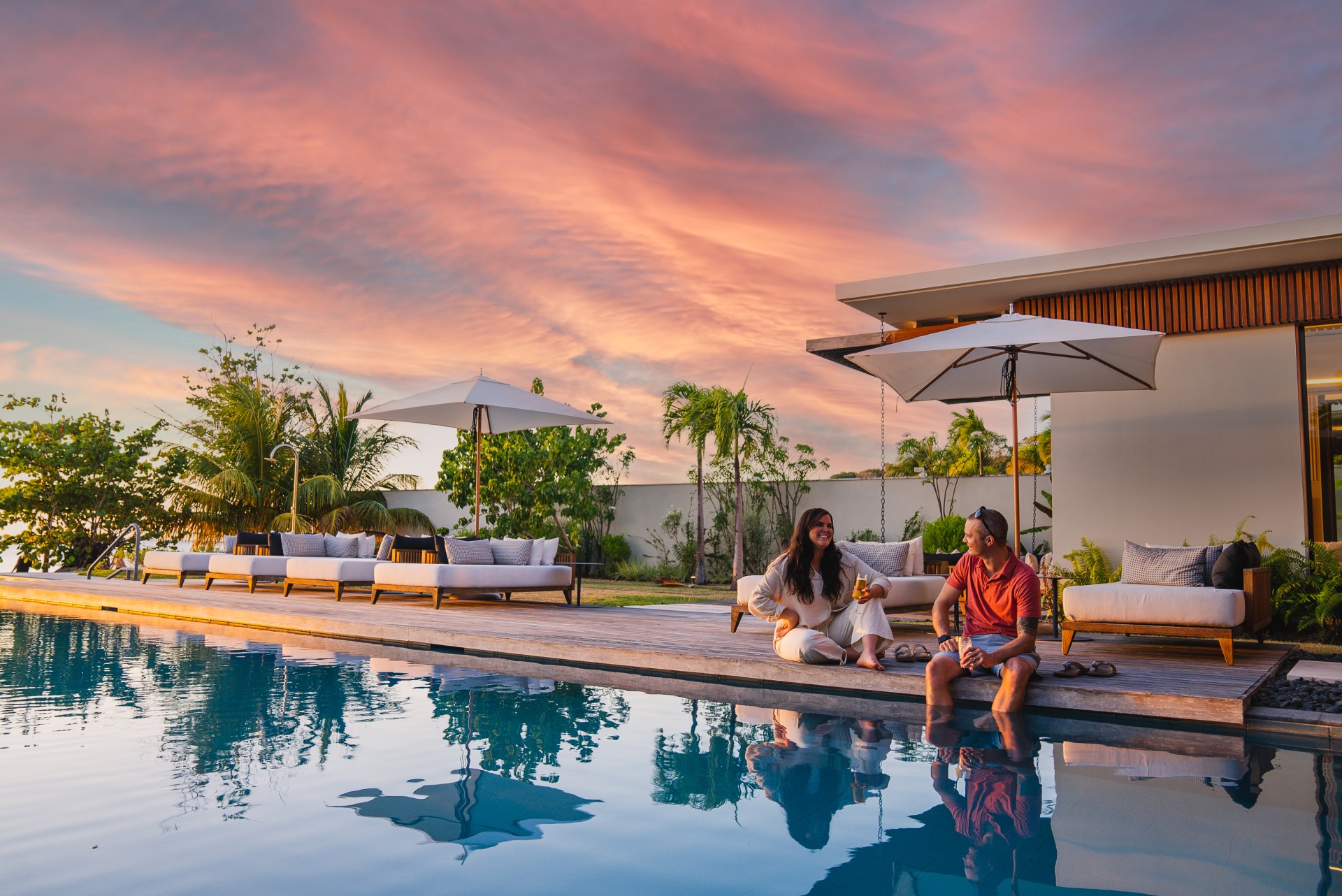 a man and woman sitting by a pool