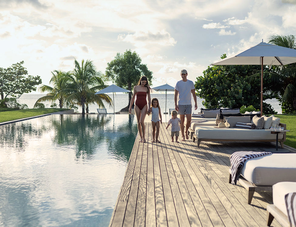 a family walking on a deck near a pool
