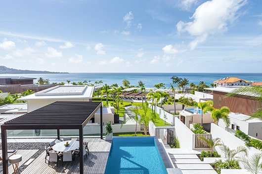 a pool in a resort with a pool and a beach in the background