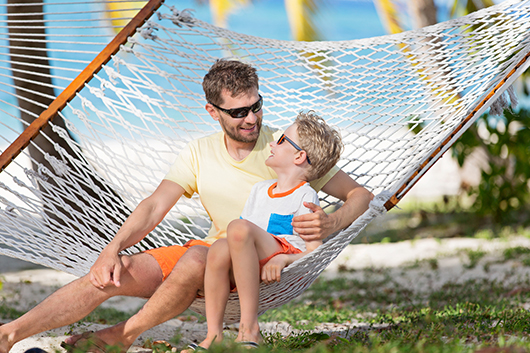 a man and child sitting in a hammock