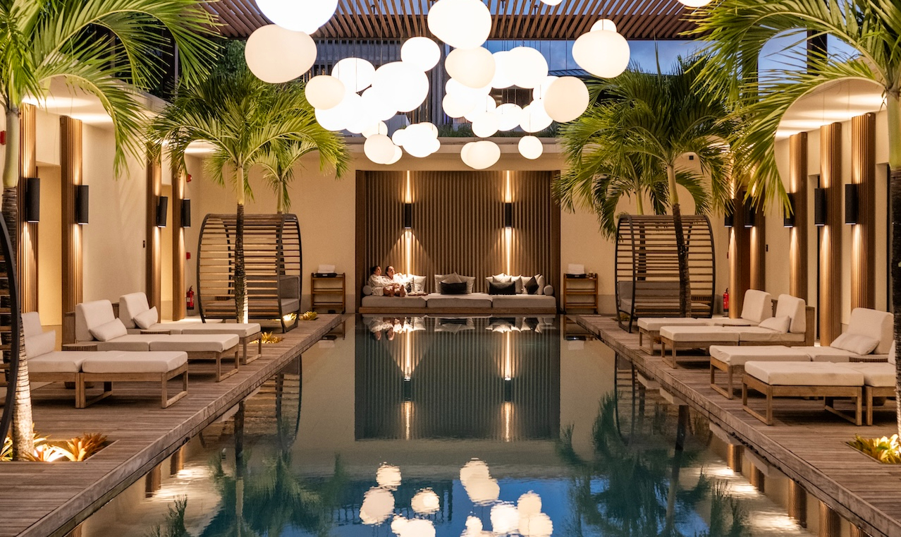 a pool with white lights and palm trees