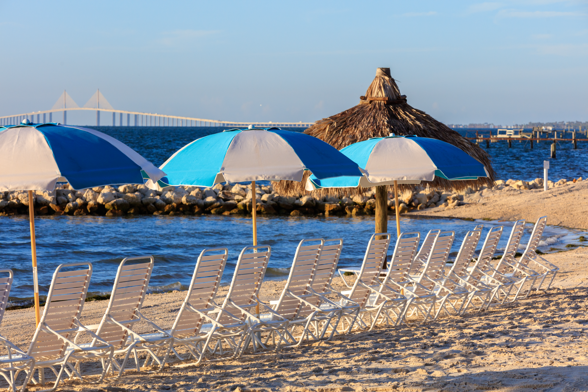 a beach with chairs and umbrellas