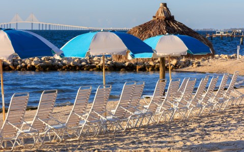 a row of chairs and umbrellas on a beach