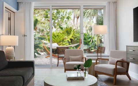 a living room with a glass door and chairs