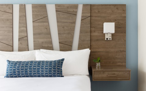 a bed with pillows and a night stand