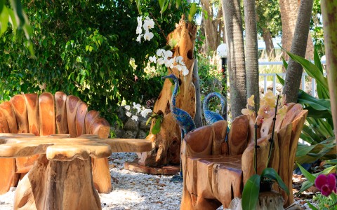 a wooden benches and tables with peacock statues