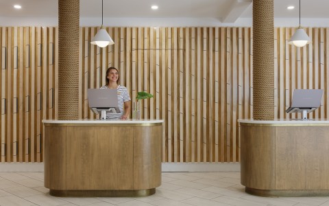 a woman standing behind a desk in a hotel