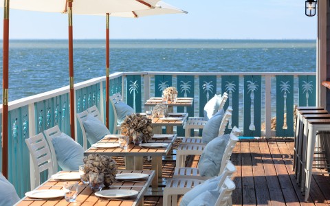 a table and chairs on a deck overlooking the ocean