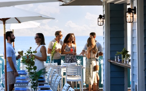 a group of people standing around tables and chairs