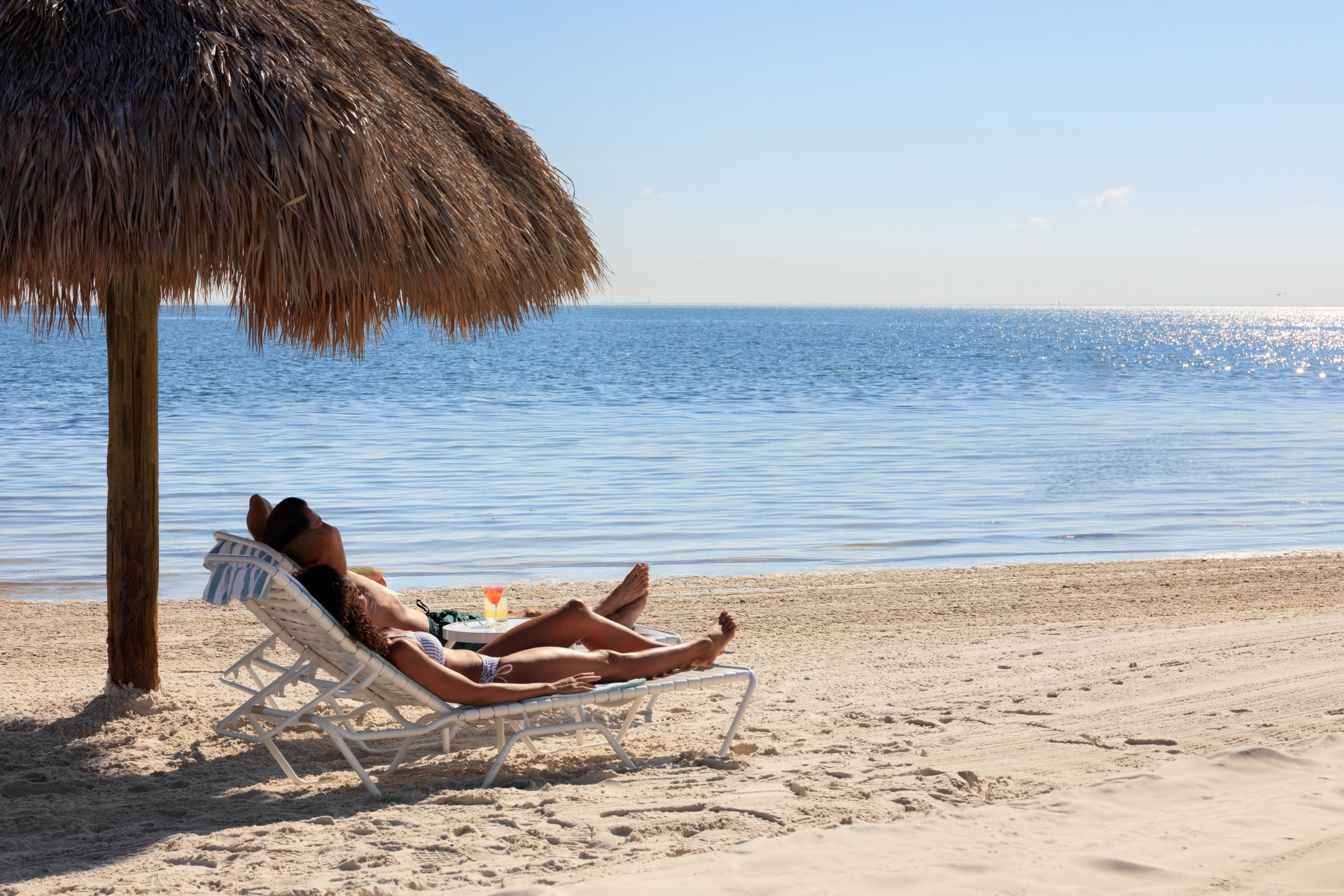 a man and woman lying on a beach chair