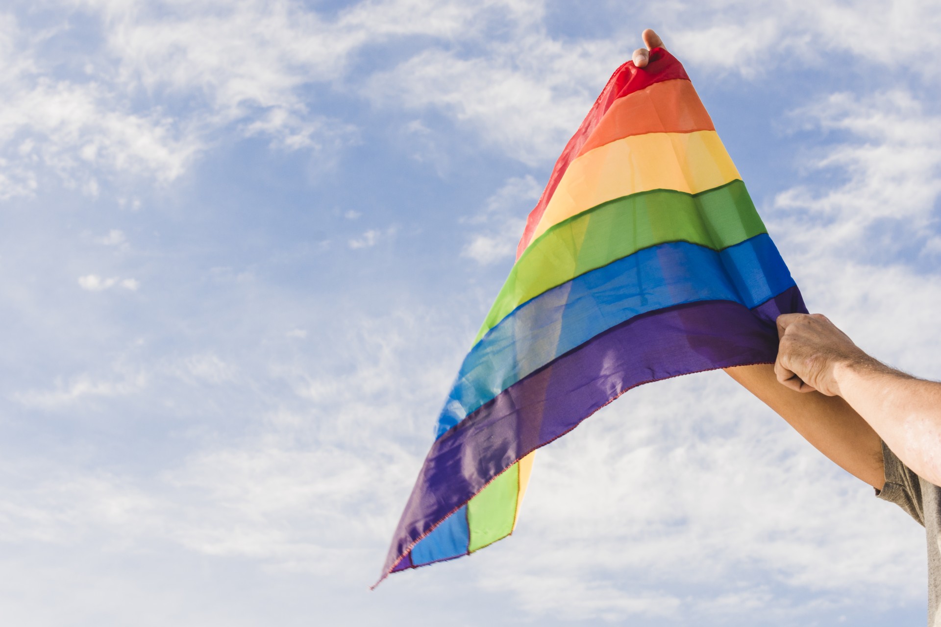 a person holding a rainbow flag