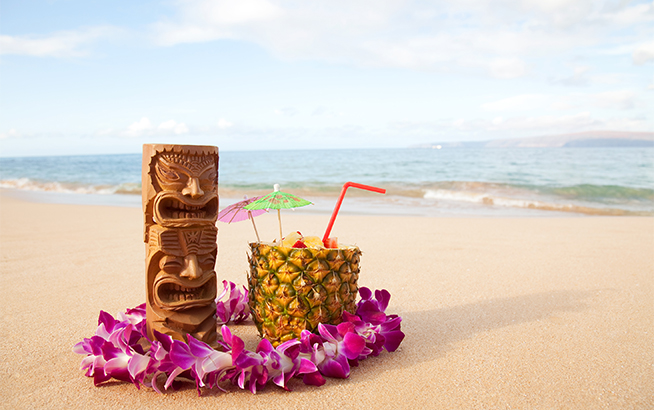 a wood carving and a drink on a beach