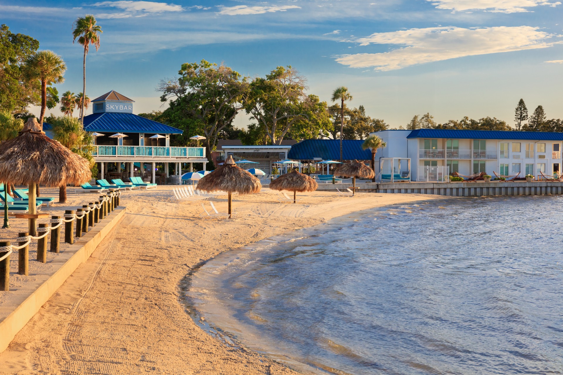 a beach with a building and umbrellas