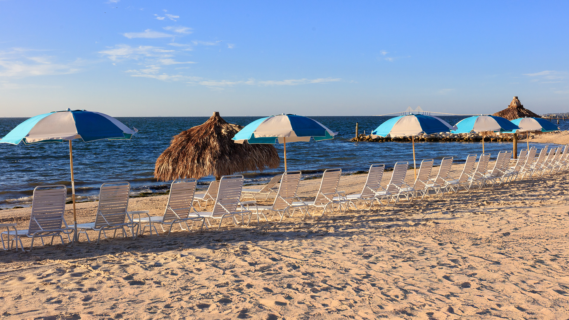 a beach with chairs and umbrellas