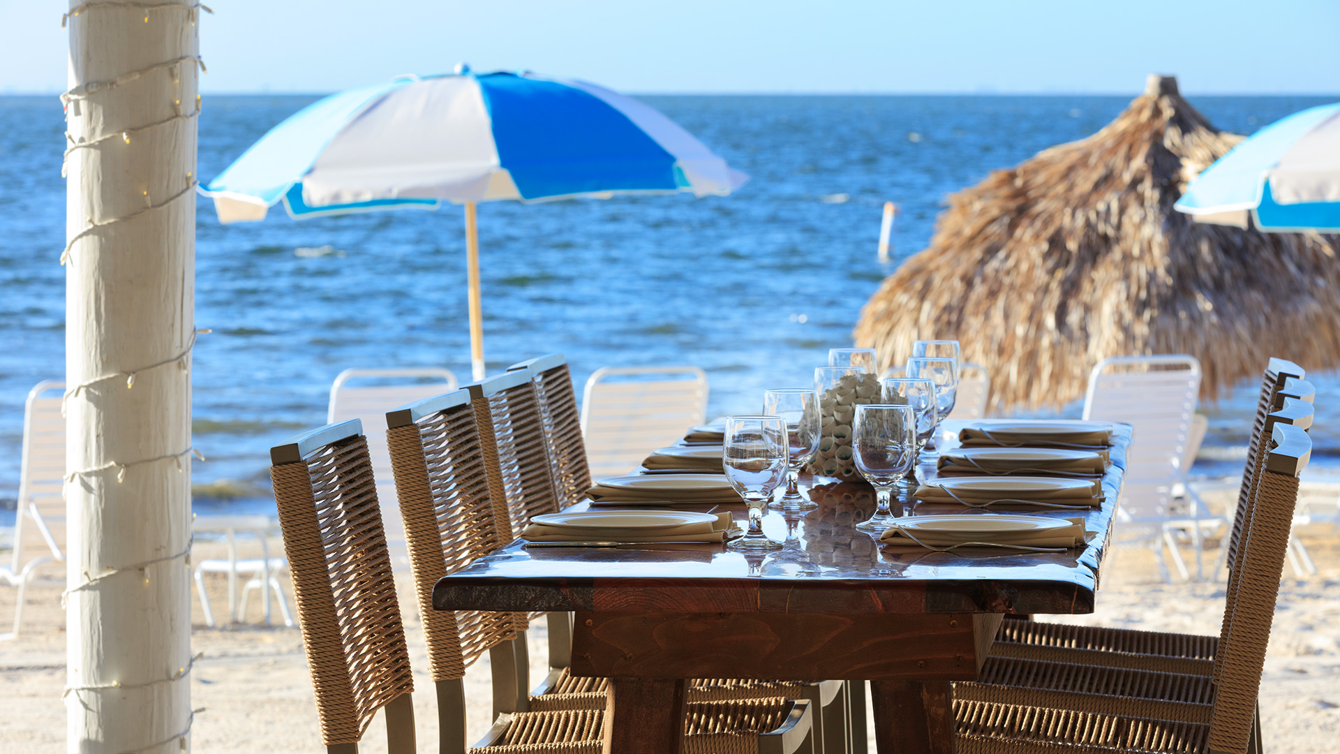 a table set for a dinner on a beach