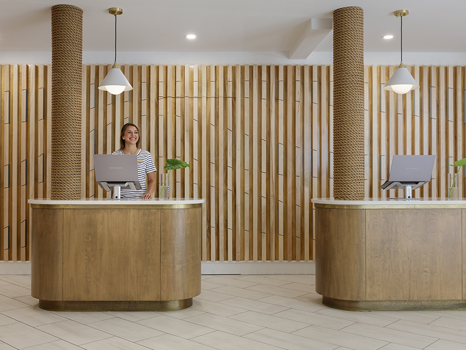 a woman standing behind a desk in a hotel