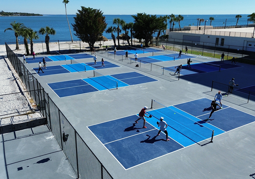 a group of people playing tennis on a tennis court