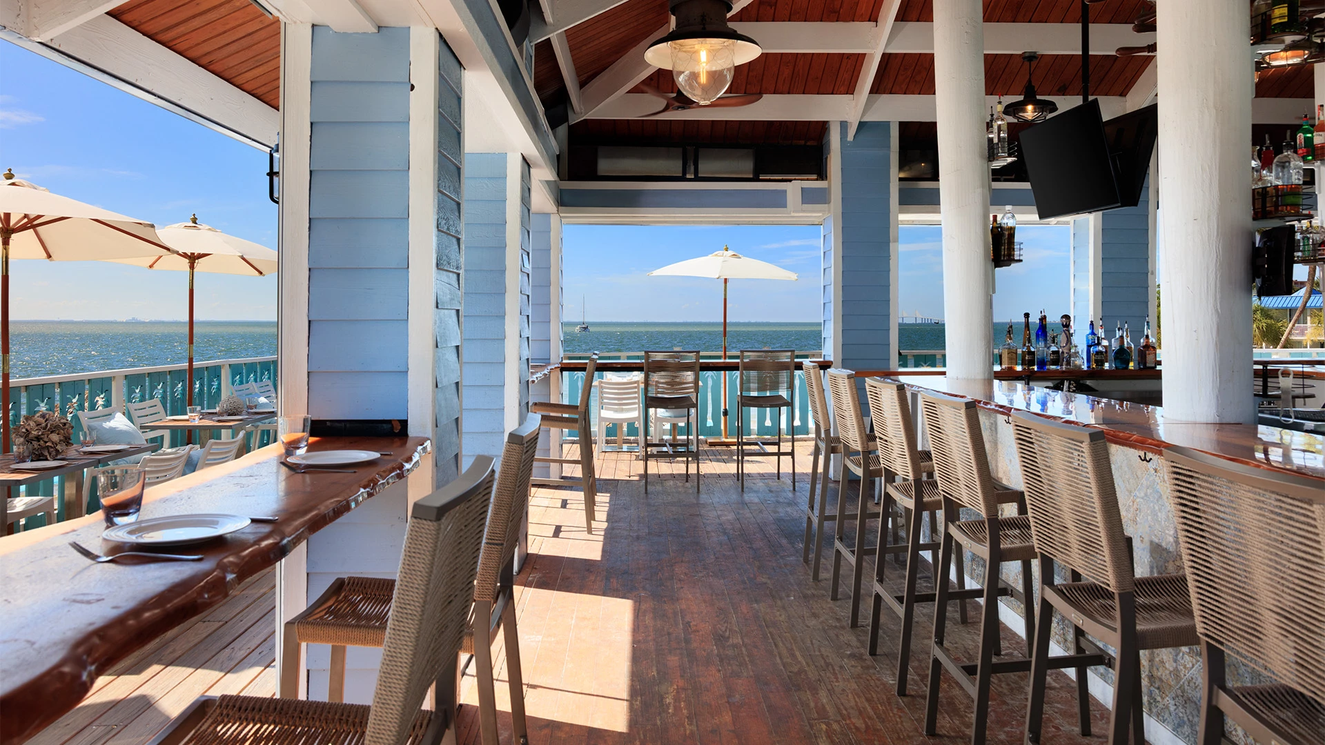 a bar with a counter and stools overlooking the ocean