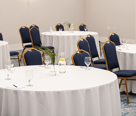 a round white tables with blue chairs
