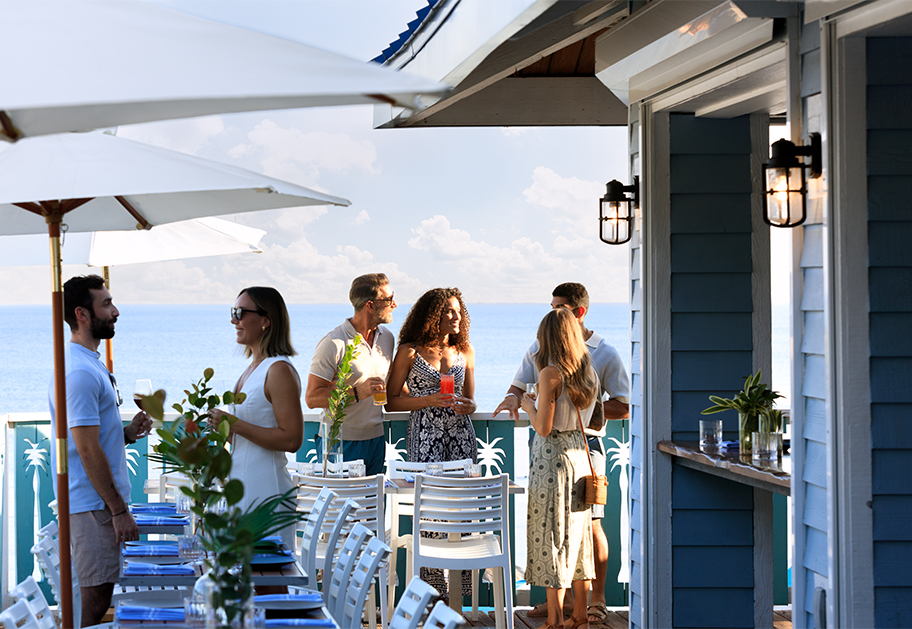 a group of people standing around a table with drinks