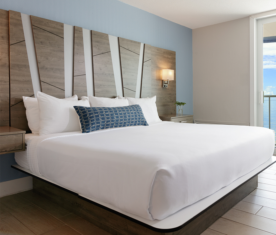 a bed with white sheets and pillows
