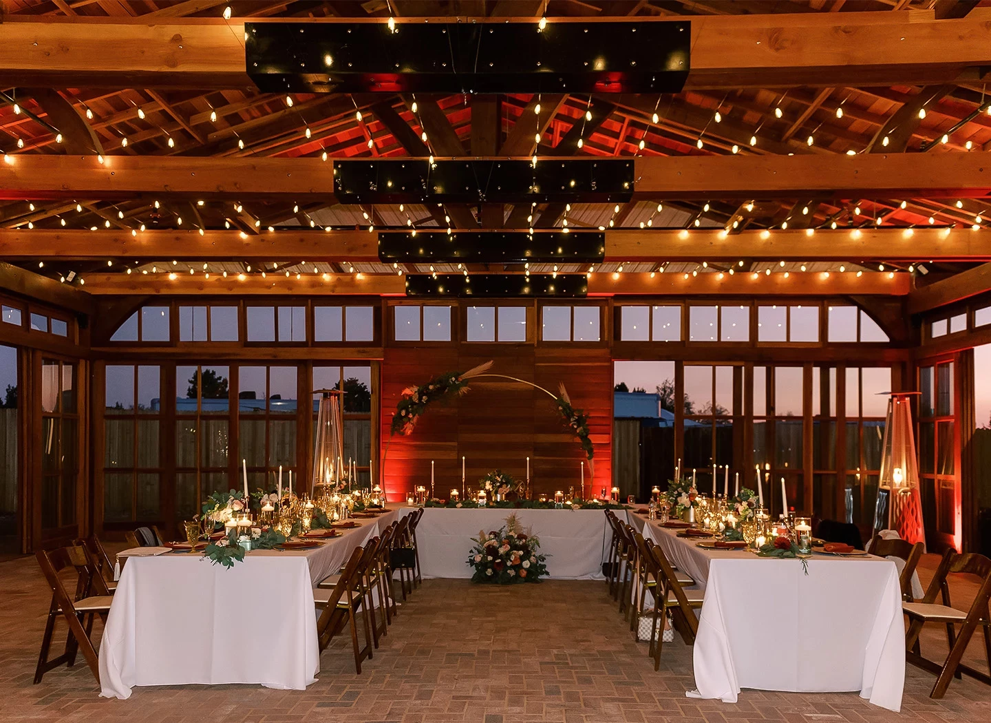 The Pavilion reception venue with candlelit tables and wooden beams