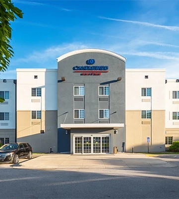 view of the candlewood suites hotel during the day with blue skies