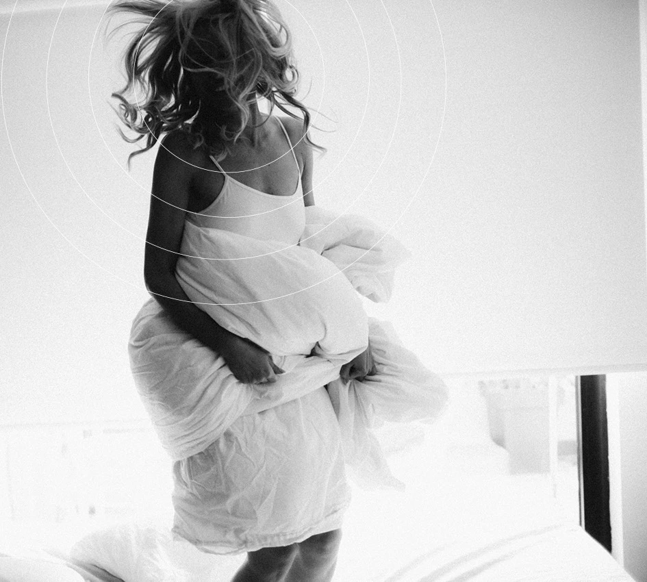 a woman holding a pillow in a bright room