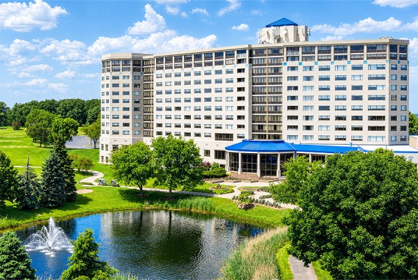 a large building with a pond in front