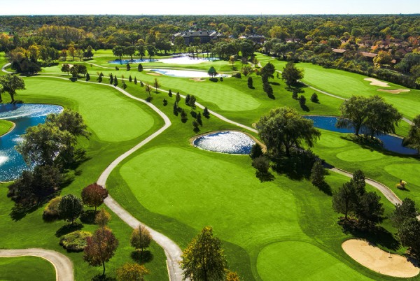 a golf course with water and trees