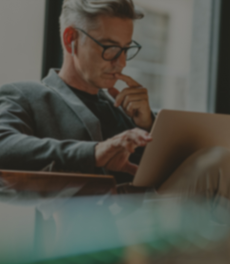 a man sitting in a chair using a laptop