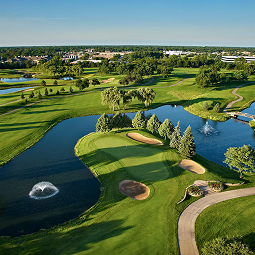 a golf course with water and trees