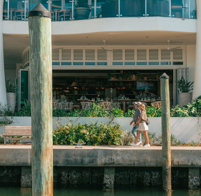 a woman and child walking on a dock