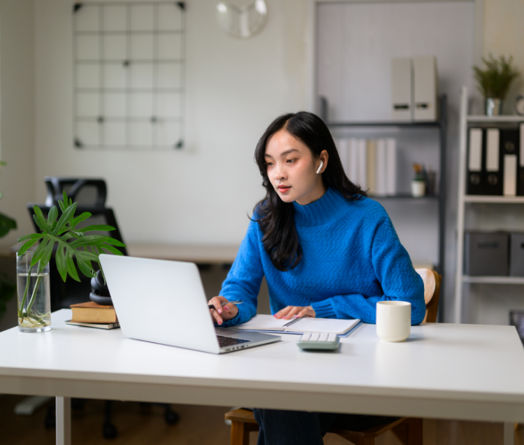 a woman sitting at a desk with a laptop