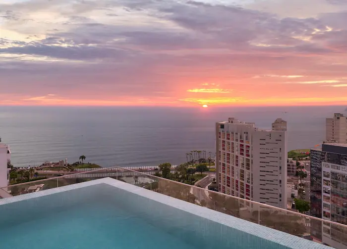 a pool overlooking a city and the ocean