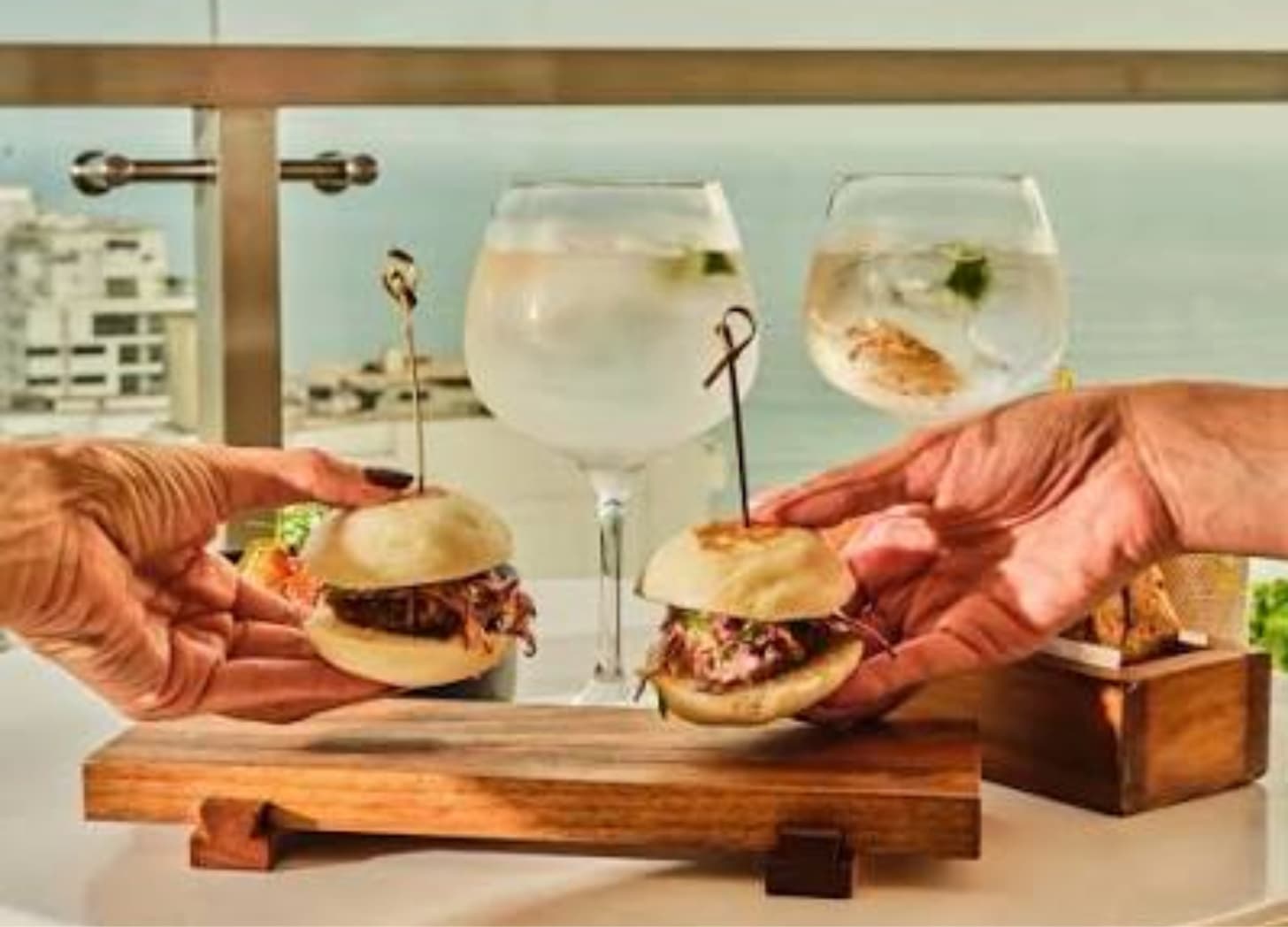 a group of hands holding small sandwiches
