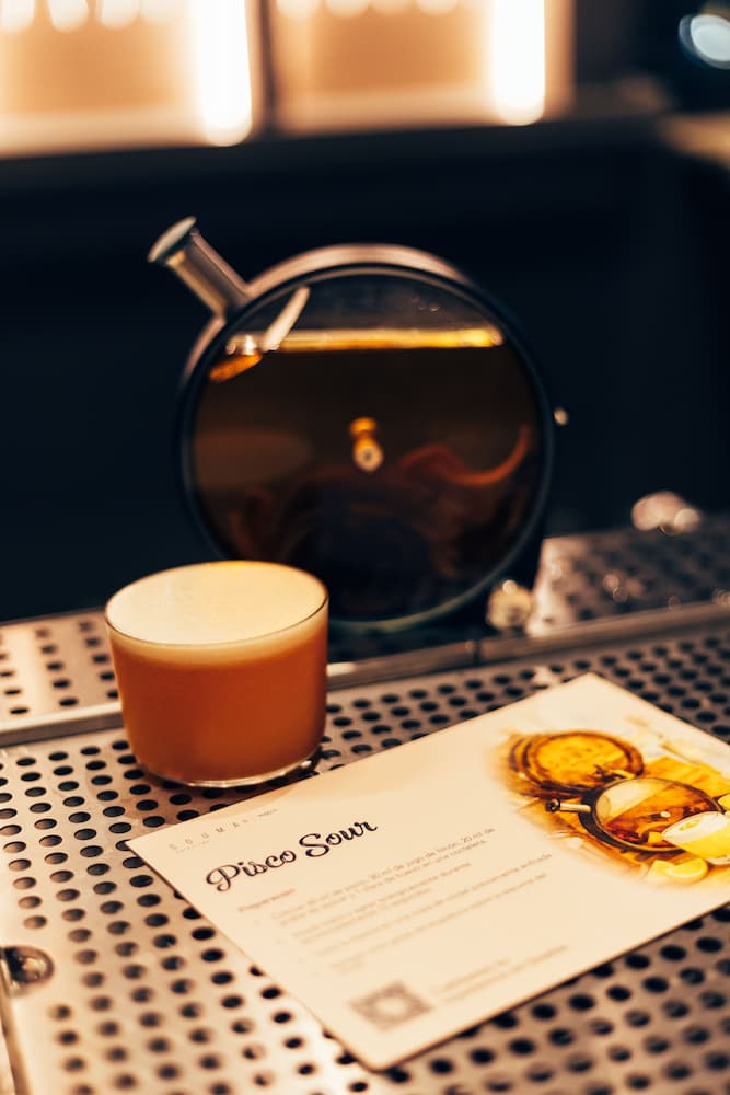 a glass of liquid next to a menu