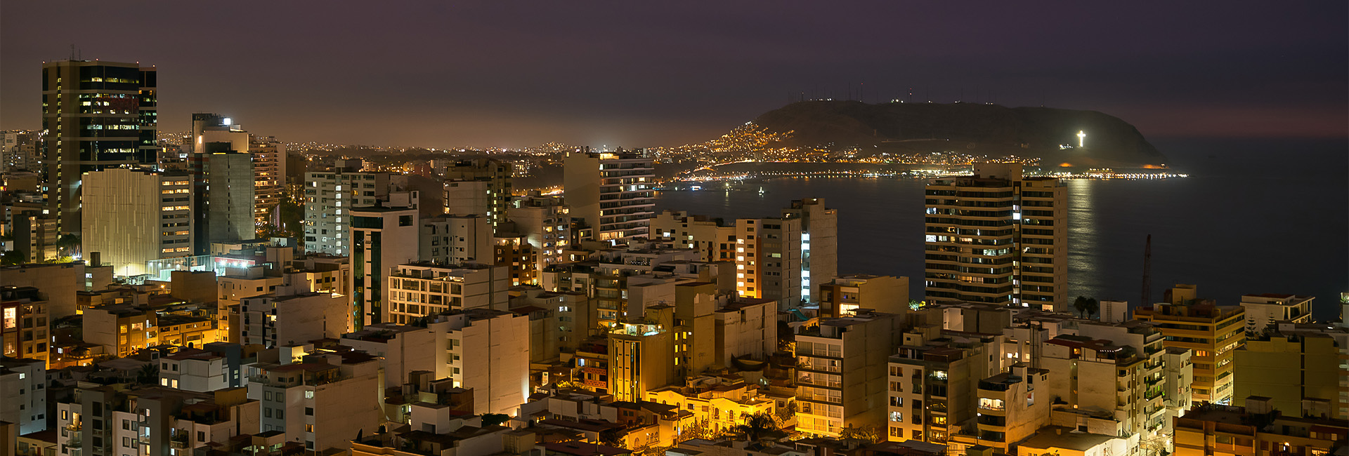 a city with lights on the side of the water