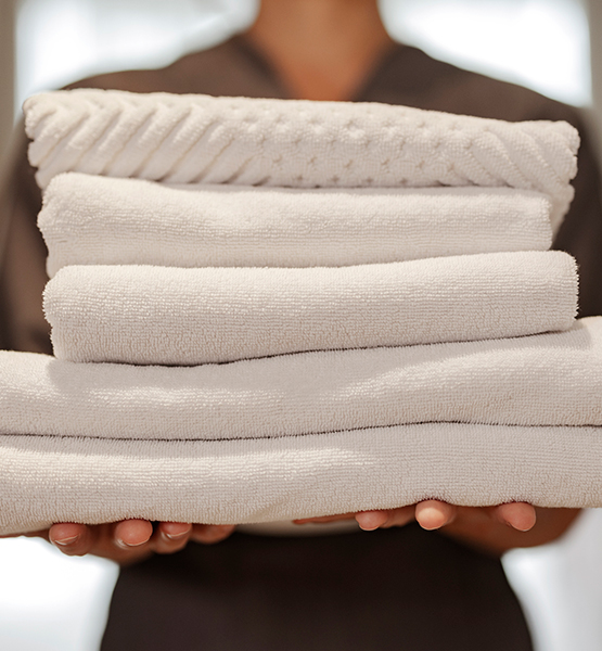 a person holding a stack of towels