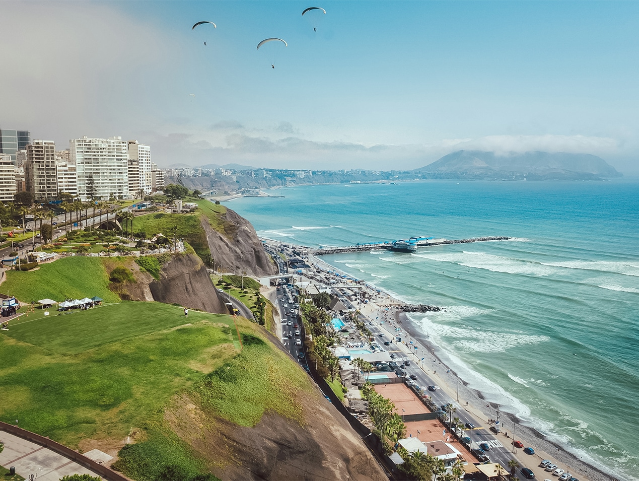 a beach with a city and a body of water