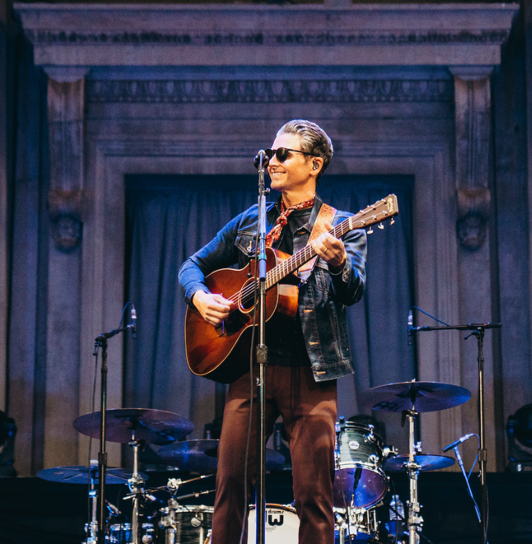 a man playing guitar on a stage