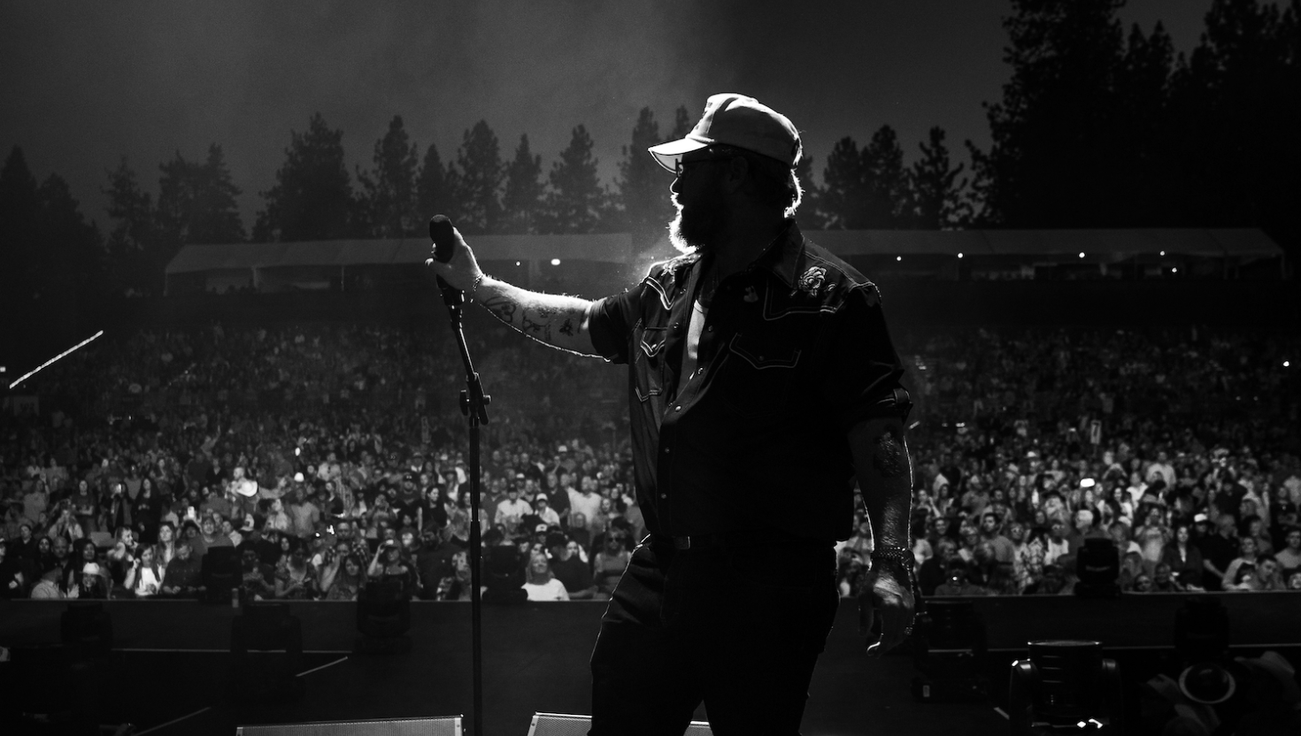 a man holding a microphone in front of a crowd