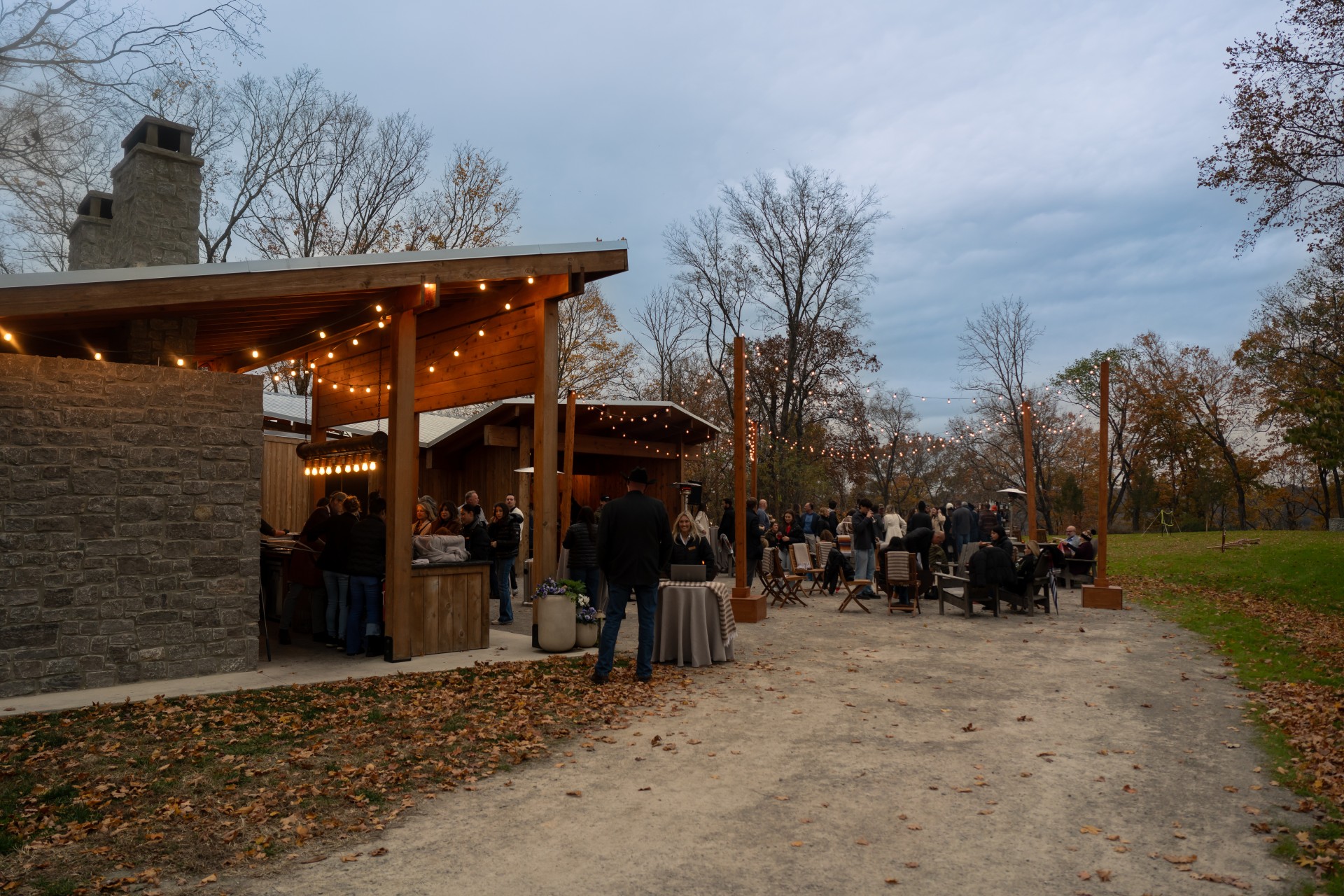 a group of people outside with tables and chairs