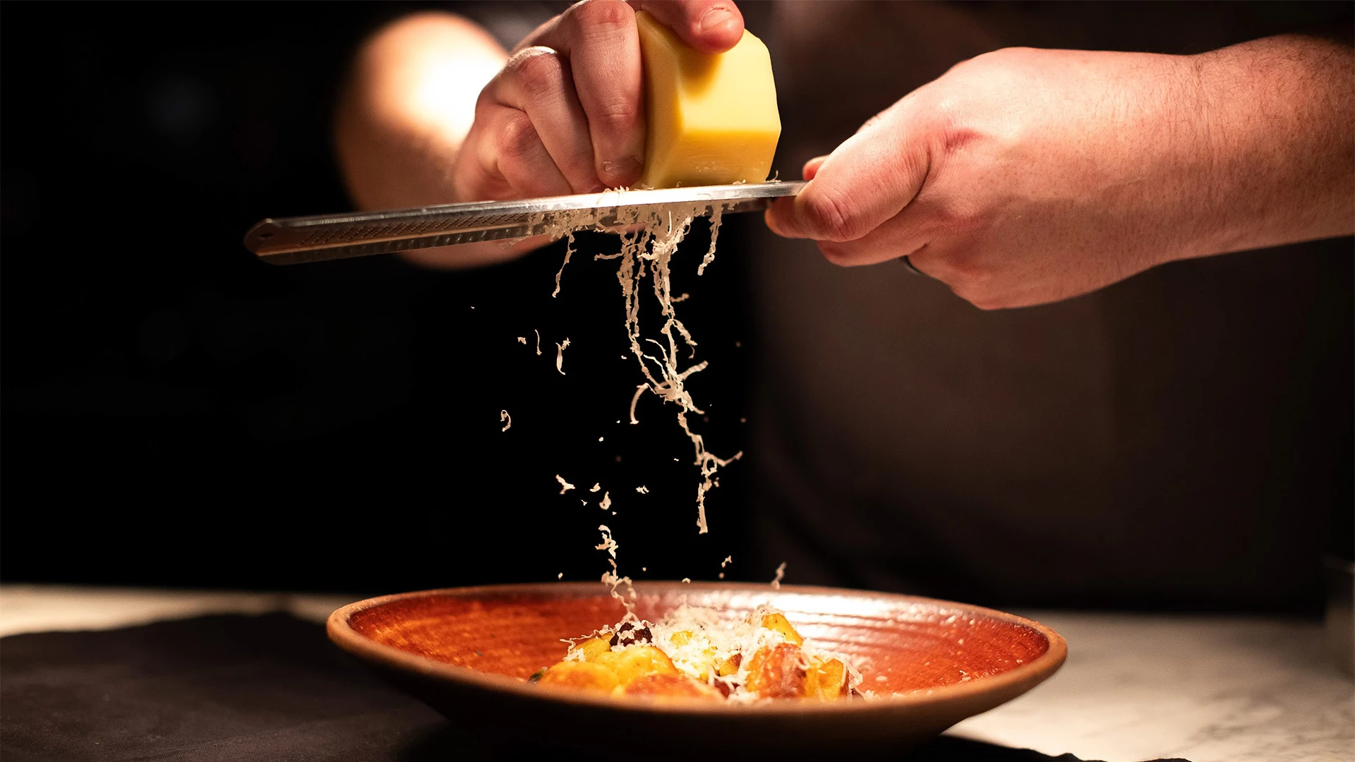 a person grating cheese on a plate